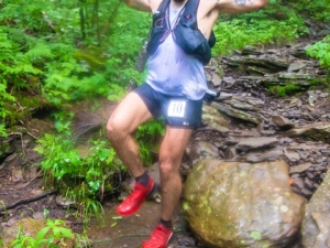 man jumping off rocks while running